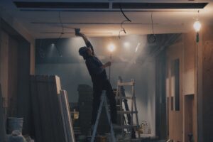 Man on ladder painting ceiling